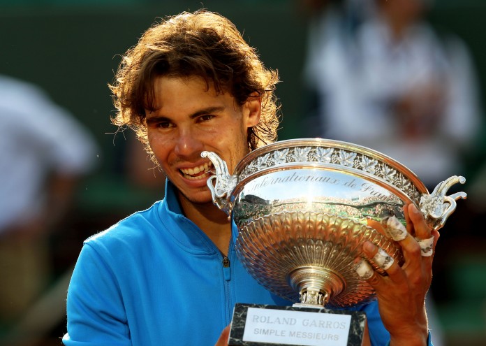 PARIS, FRANCE - JUNE 05: Champion Rafael Nadal of Spain bites the trophy following his record equalling sixth victory during the men's singles final match between Rafael Nadal of Spain and Roger Federer of Switzerland on day fifteen of the French Open at Roland Garros on June 5, 2011 in Paris, France. (Photo by Clive Brunskill/Getty Images)