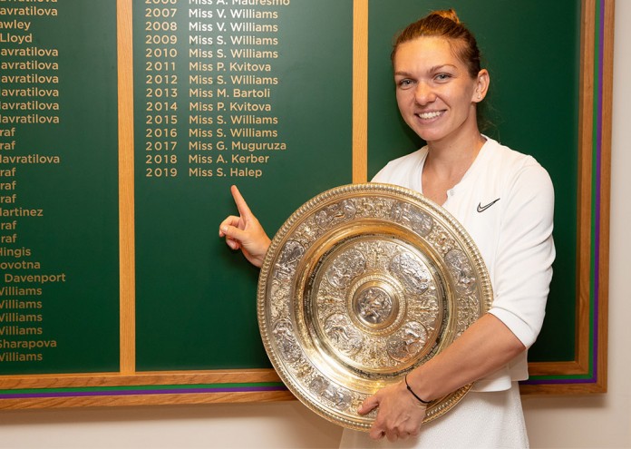 Simona Halep (ROU) stands next to the Champions board with the Venus Rosewater Dish after winning the Ladies' Singles final. The Championships 2019. Held at The All England Lawn Tennis Club, Wimbledon. Day 12 Saturday 13/07/2019: Credit: AELTC/Ben Queenborough