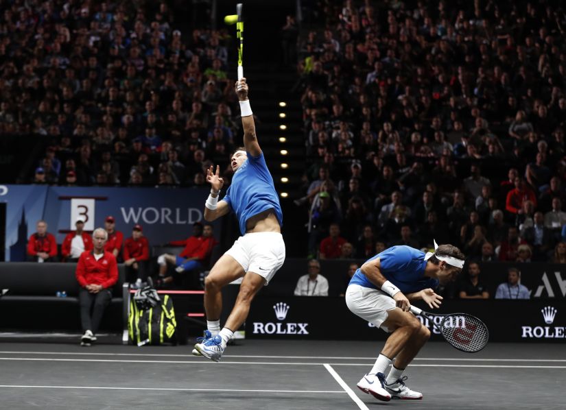 Europe's Roger Federer, right, crouches as his teammate Rafael Nadal, left, returns a ball to World's Jack Sock and Sam Querrey during their Laver Cup doubles tennis match in Prague, Czech Republic, Saturday, Sept. 23, 2017. (AP Photo/Petr David Josek)