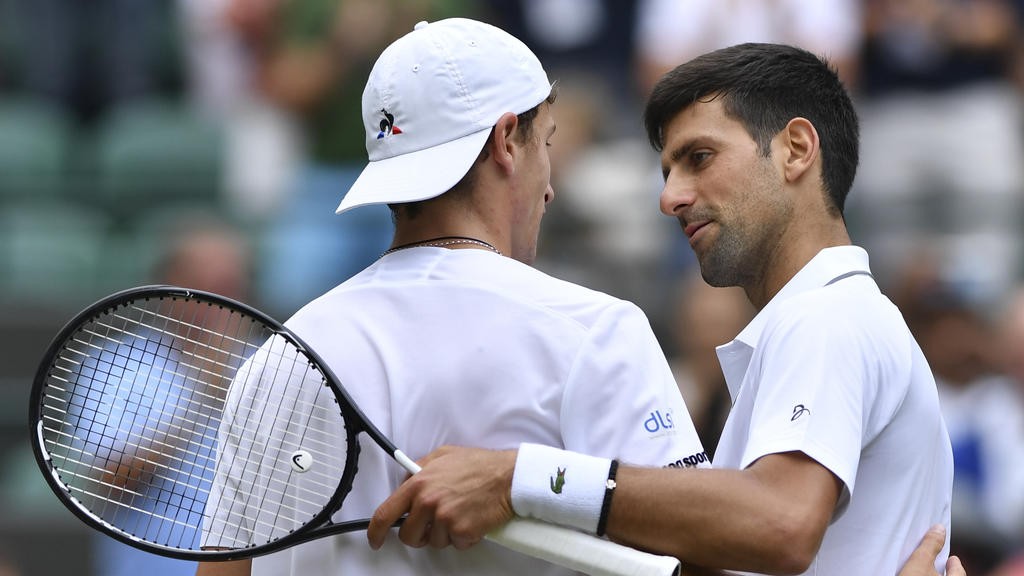 Serbia's Novak Djokovic (R) shakes hands with France's Ugo Humbert (L) after Djokovic won their men's singles fourth round match on the seventh day of the 2019 Wimbledon Championships at The All England Lawn Tennis Club in Wimbledon, southwest London, on July 8, 2019. (Photo by GLYN KIRK / AFP) / RESTRICTED TO EDITORIAL USE