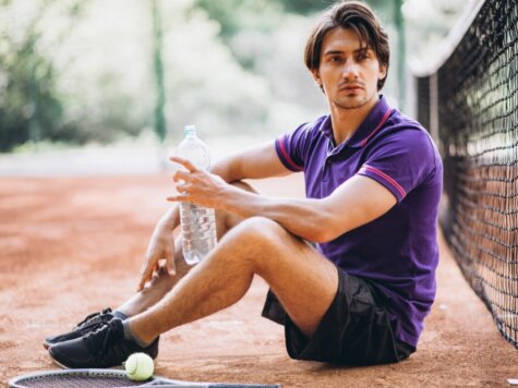 Young man tennis player at the court